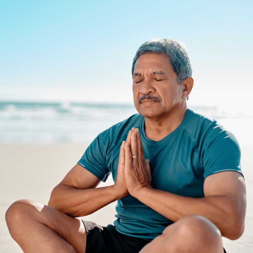 Un homme qui pratique le breathwork sur la plage