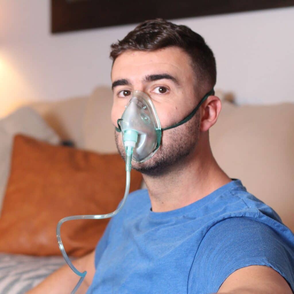 Un homme qui respire dans un masque à oxygène