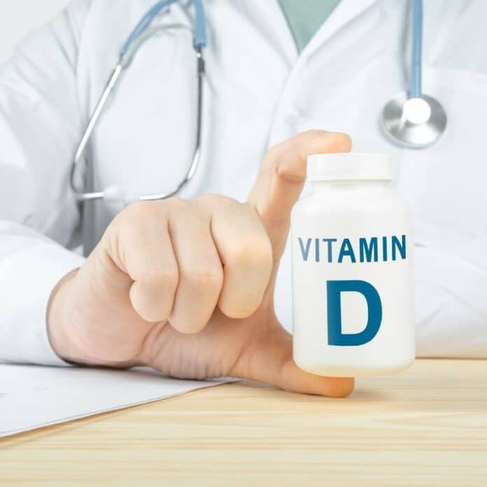 Un médecin présente un flacon de vitamine D